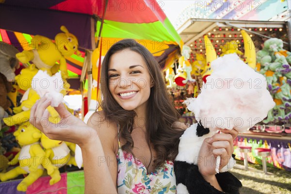 Caucasian woman eating cotton candy at carnival