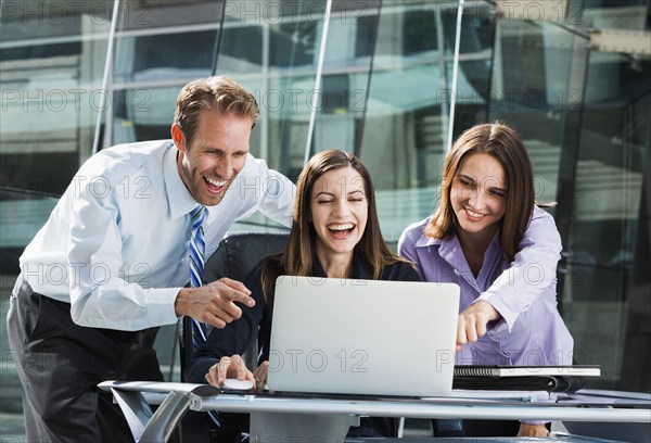 Caucasian business people watching laptop