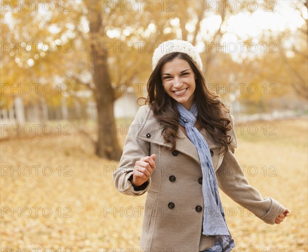 Caucasian woman walking in autumn leaves