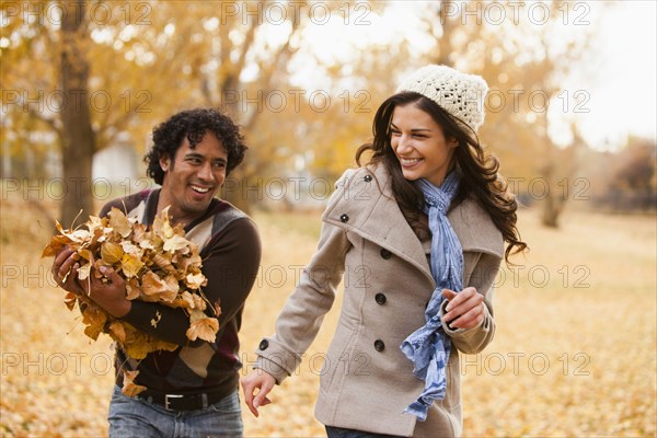 Couple playing in autumn leaves