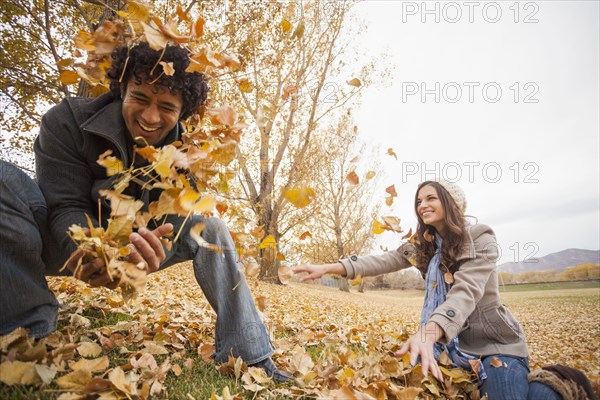 Couple playing in autumn leaves