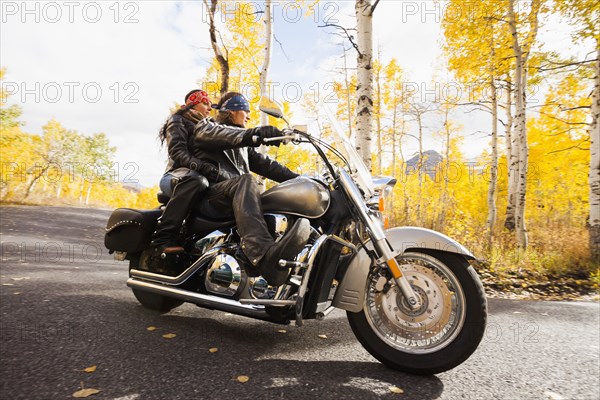Caucasian couple riding motorcycle