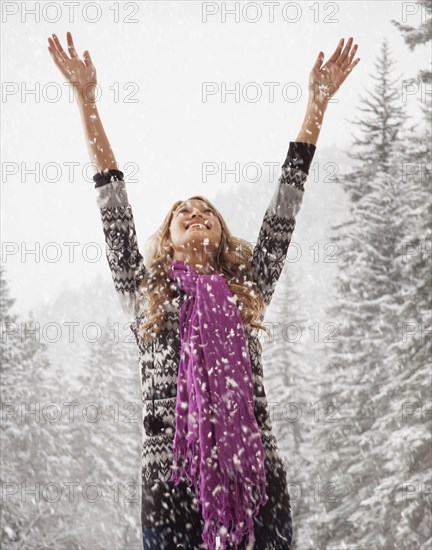 Mixed race woman playing in snow