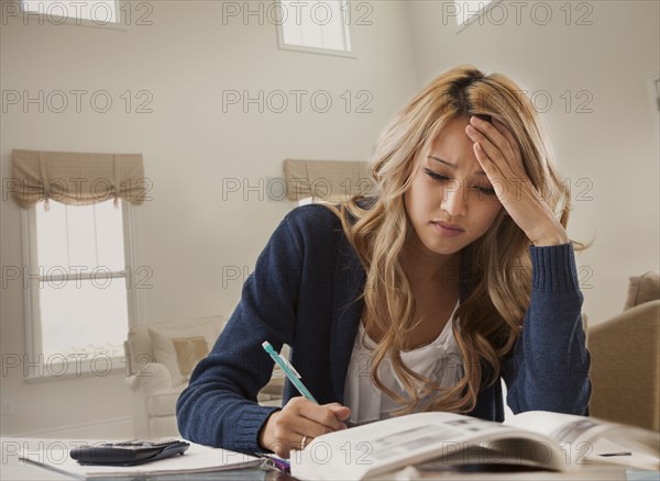 Anxious mixed race woman studying