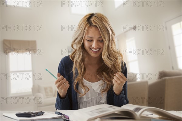 Mixed race woman cheering and studying