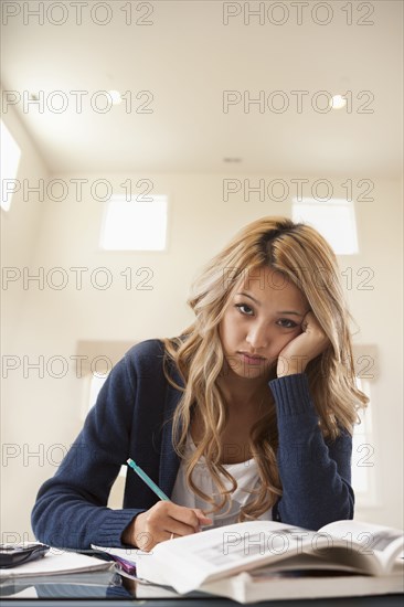 Anxious mixed race woman studying