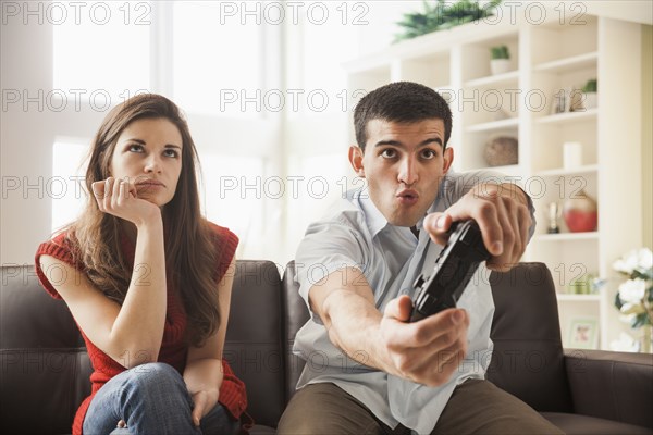 Woman watching boyfriend play video games