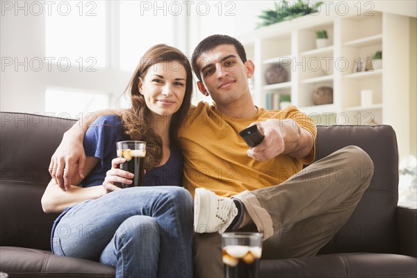 Couple watching television on sofa