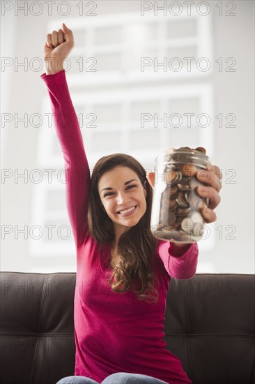 Caucasian woman cheering with jar of change