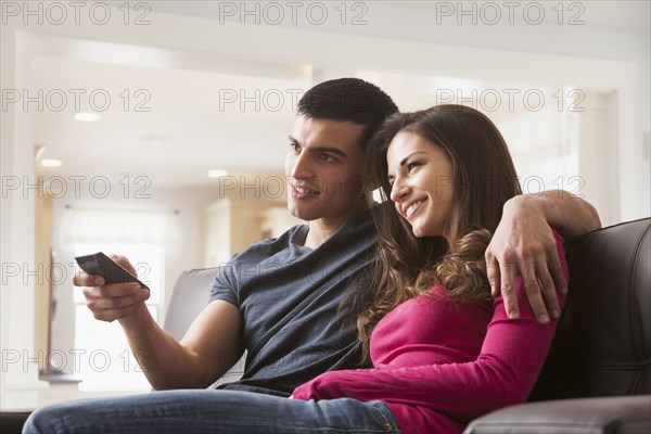 Couple watching television on sofa