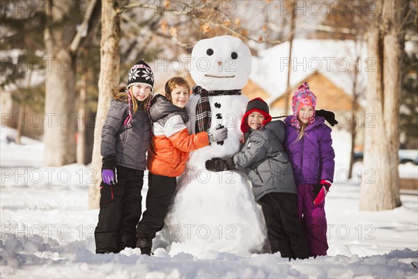 Caucasian family building snowman in snow