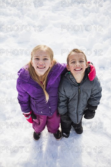 Caucasian children standing in snow outdoors