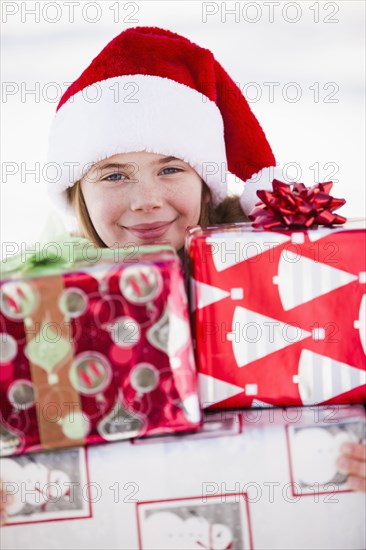 Caucasian boy in Santa hat holding Christmas presents