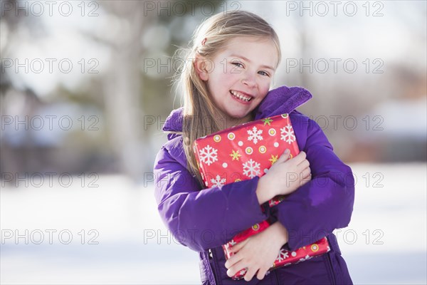 Caucasian girl holding Christmas present