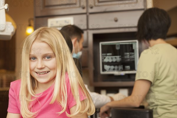 Girl with braces smiling in dentist's office