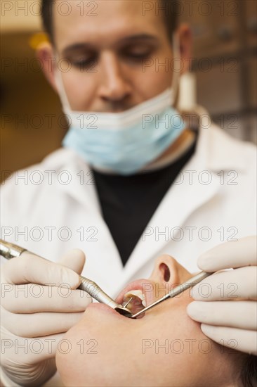 Caucasian dentist examining woman's teeth in office