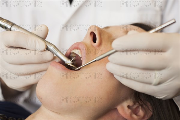 Caucasian dentist examining woman's teeth in office