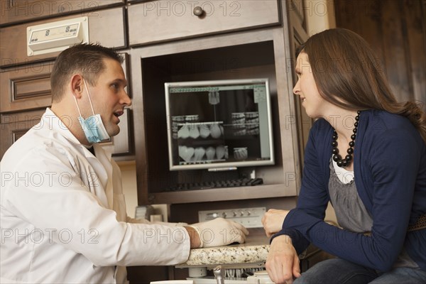 Caucasian dentist and woman talking in office