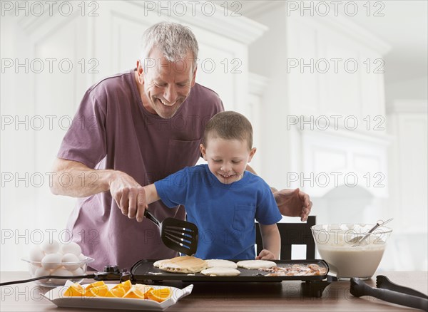 Caucasian father and son cooking breakfast