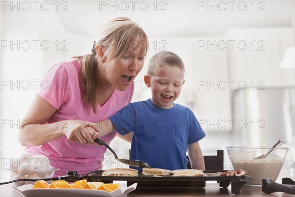 Caucasian mother and son cooking breakfast