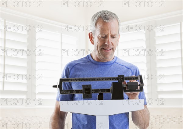 Caucasian man weighing himself