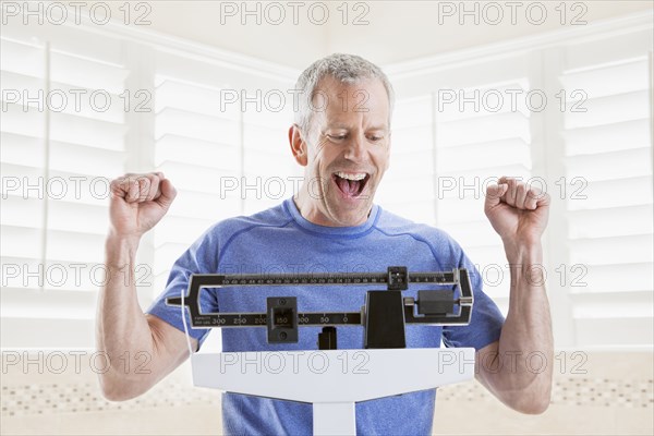 Caucasian man weighing himself