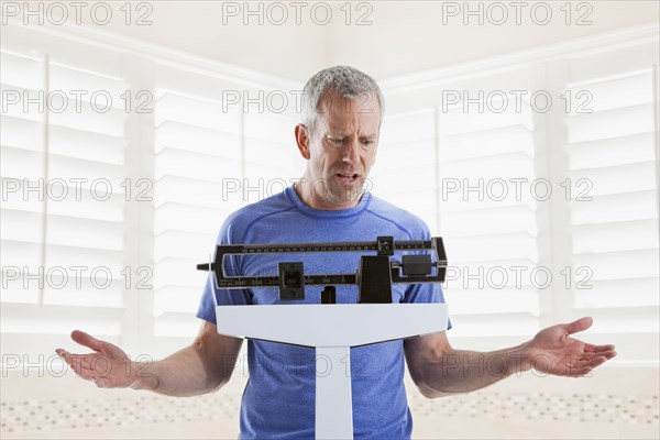 Caucasian man weighing himself