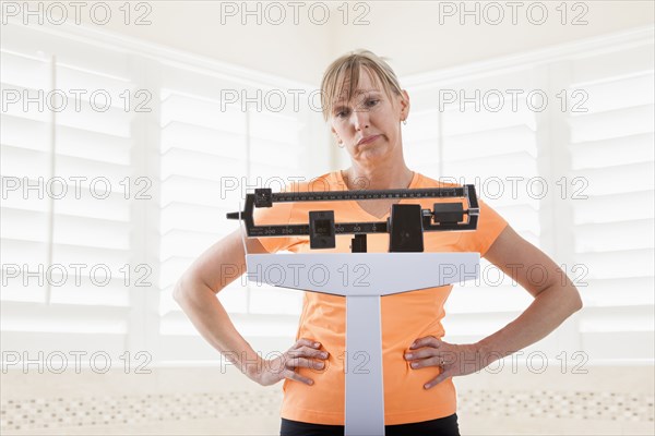 Caucasian woman weighing herself
