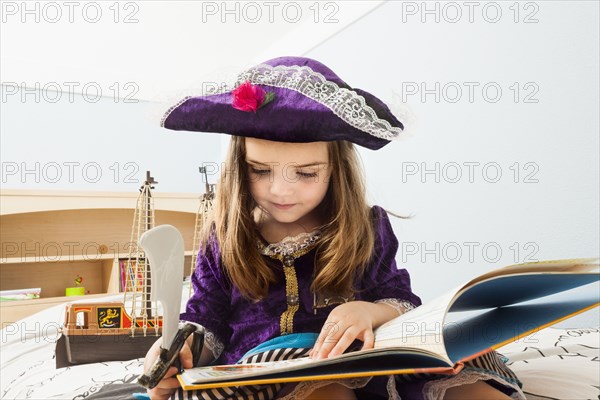 Caucasian girl reading book on bed