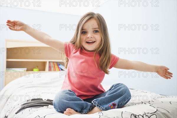 Caucasian girl sitting on bed