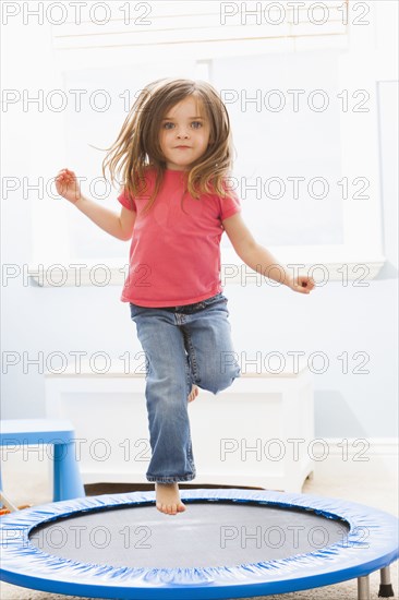 Caucasian girl jumping on trampoline