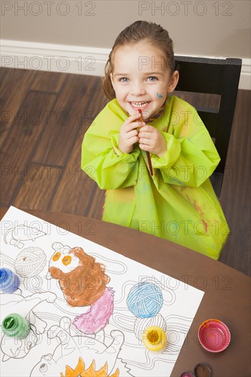 Caucasian girl painting at table