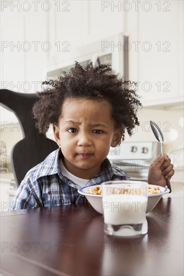 Mixed race boy eating at table