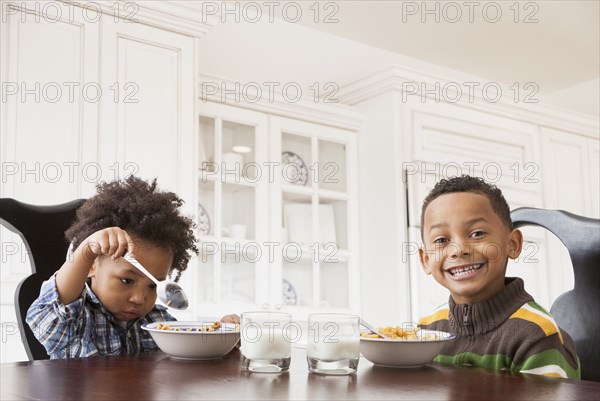 Mixed race boys eating at table