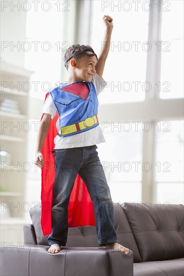 Mixed race boy playing superhero