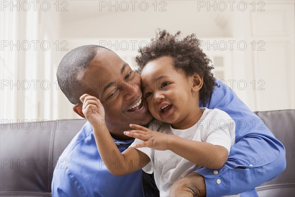 Father and son relaxing on sofa