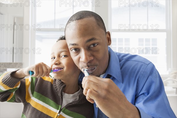 Father and son brushing their teeth