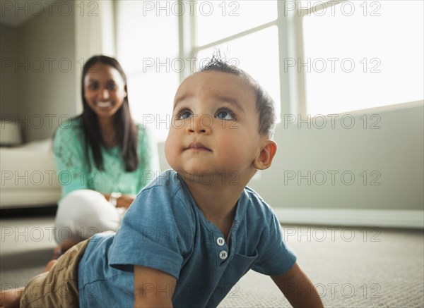 Baby boy crawling in living room
