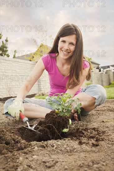 Caucasian woman planting in backyard