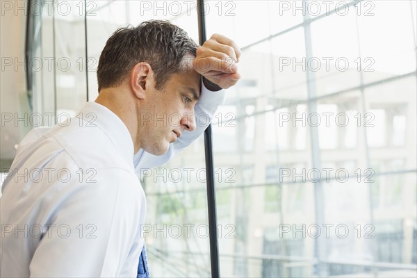 Caucasian businessman leaning on office window