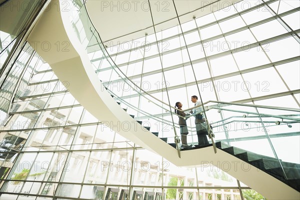 Business people talking on office staircase