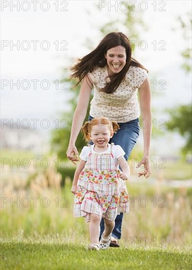 Caucasian mother and daughter playing outdoors
