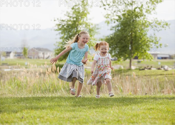 Caucasian girls running in grass