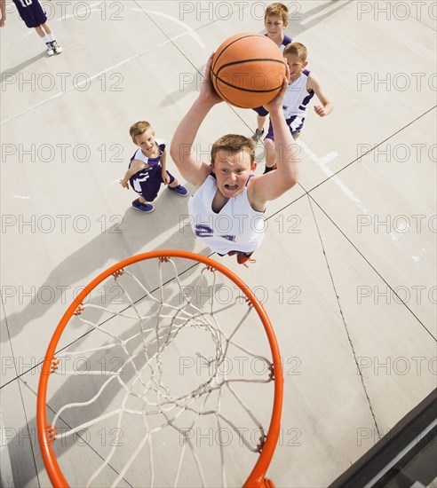 Caucasian boys playing basketball on court