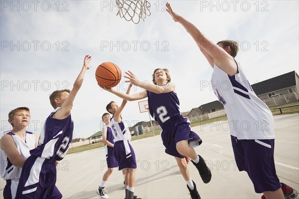 Caucasian boys playing basketball on court