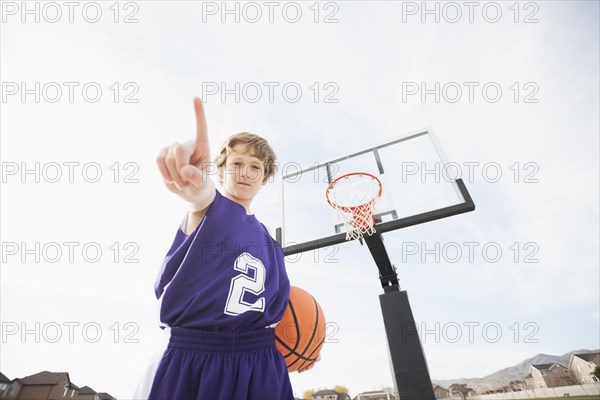 Caucasian basketball player holding out finger on court