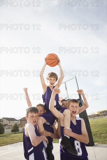 Caucasian basketball team cheering on court