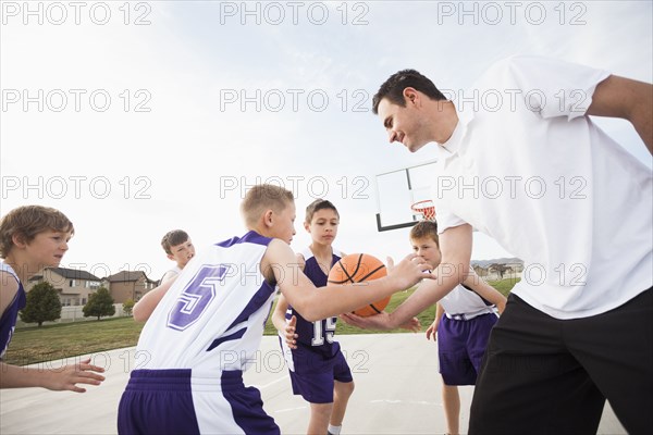 Caucasian basketball team playing on court