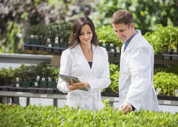 Caucasian scientists working in greenhouse