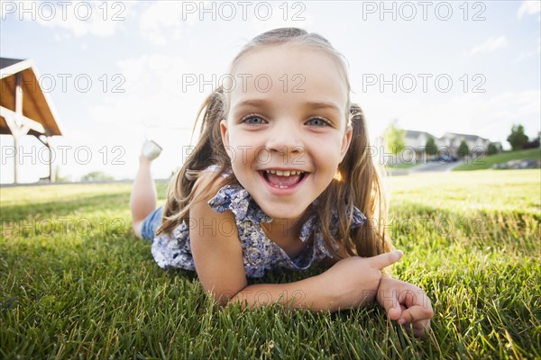 Caucasian girl laying in grass